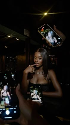 a woman taking a selfie with her cell phone in front of her and two people holding up their phones