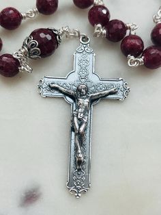 Wonderful wire-wrapped Saint Michael and Crown of Thorns Tenner.   Medals, Bead Caps and Chain:  Sterling Silver  Wire:  20 gauge argentium silver  Beads:  8 and 10mm faceted rubies Silver Round Beaded Gemstones For Gifts, Silver Round Bead Gemstones For Gifts, Crucifix Jewelry With Faceted Beads As Gift, Crucifix Jewelry With Faceted Beads For Gift, Crucifix Shaped Jewelry With Faceted Beads As Gift, Silver Faceted Round Beads Gemstones, Silver Beaded Crucifix Jewelry, Silver Rosary With Faceted Beads For Gift, Silver Rosary With Faceted Beads As Gift