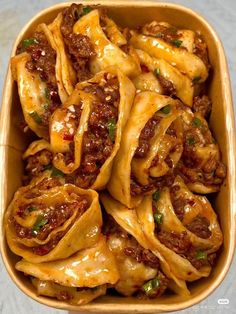 a bowl filled with stuffed shells covered in cheese and meat sauce on top of a table