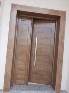 two wooden doors are open in front of a white wall