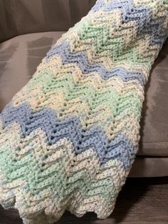 a crocheted blanket sitting on top of a couch