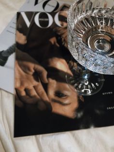 an image of a magazine with a glass on it