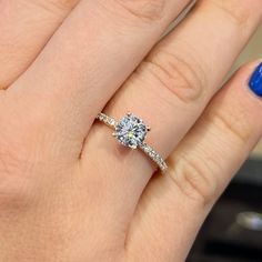 a close up of a person's hand with a diamond ring on their finger