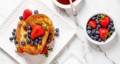 french toast with strawberries and blueberries on top