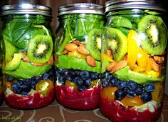 four mason jars filled with fruit and vegetables