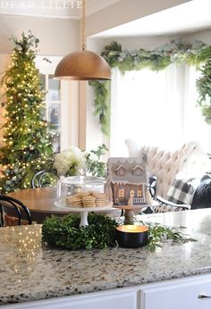 a kitchen counter with christmas decorations and cookies on the table in front of it,