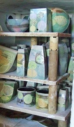 a shelf filled with lots of vases and bowls