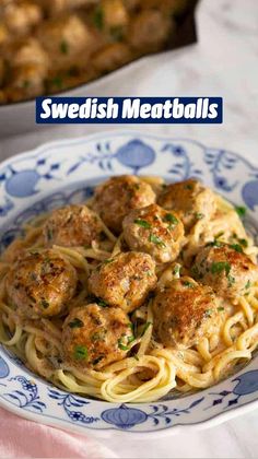 pasta with meatballs and parsley in a blue and white bowl on a table