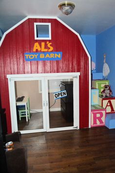 a toy barn with wooden floors and red walls