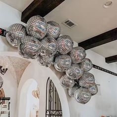 a room filled with lots of shiny balls hanging from it's ceiling next to a doorway