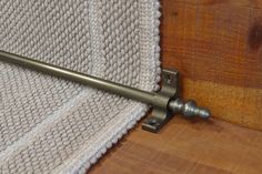 a close up of a metal handle on a wooden door with a knitted cloth in the background