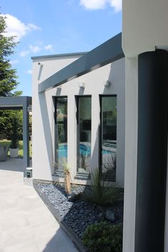 a white house with a pool in the back yard and graveled walkway leading up to it