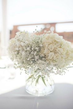 a vase filled with white flowers on top of a table