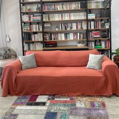 a living room filled with lots of furniture and bookshelves covered in orange covers