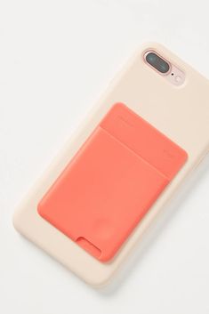 an iphone case with a card holder attached to the back of it, on a white surface