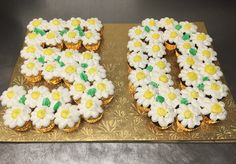 two cupcakes that are shaped like the number 50 and decorated with daisies