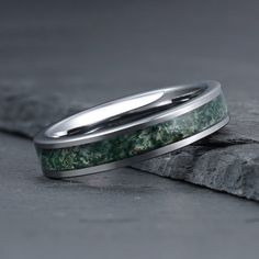 two wedding bands with green and white marble inlays on top of each other