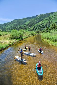 three people are paddling on their surfboards in the water