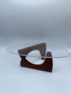 a wooden and glass coffee table with an upside down design on the top, against a white background