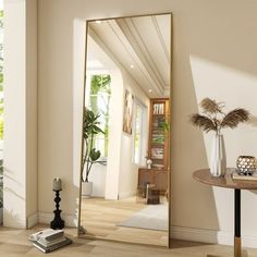 a mirror sitting on top of a wooden floor next to a table