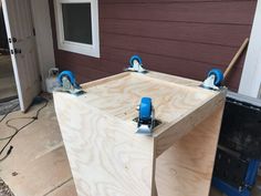 two pieces of plywood sit in front of a house with tools attached to it