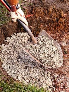 someone is digging dirt in the ground with a shovel and some gloves on their feet