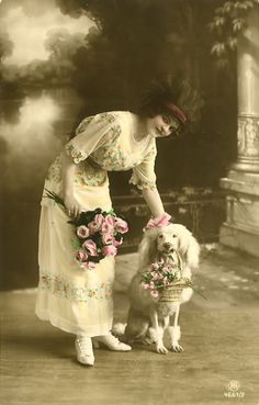 an old photo of a woman and her dog with flowers in front of the camera