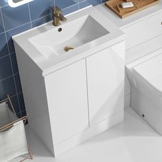 a white sink and toilet in a room with blue tiles on the wall behind it