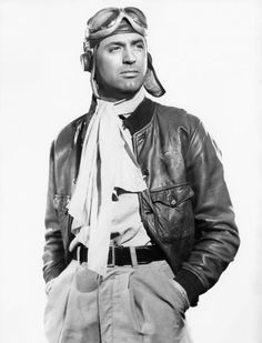 black and white photograph of a man wearing an airplane pilot's hat, scarf, and leather jacket