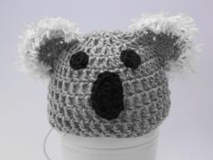 a crocheted koala hat is sitting on top of a cup