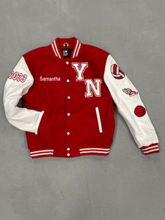 Young Nation Sports Varsity Jacket is made with its wool and leather, YN on from with name on other side as well, year embroidered on the sleeve, Sports logos embroidered on the other sleeve, and name stitched with leather on the back. This jacket is made for school kids or anyone that ever played a sport, with its custom made style fit just for you, its stylish, trendy, drippy, comfy, and fashionable wear is a must have. Wool Outerwear With Embroidered Logo And Long Sleeves, Wool Outerwear With Embroidered Logo, Wool Varsity Jacket With Embroidered Logo And Baseball Collar, Varsity Jacket With Embroidered Logo For Sports, Sports Varsity Jacket With Embroidered Logo, White Varsity Jacket With Embroidered Patch For College, Urban Winter Varsity Jacket With Embroidered Patch, Urban Style Varsity Jacket With Embroidered Patch For Winter, Classic Long Sleeve Varsity Jacket With Embroidered Logo