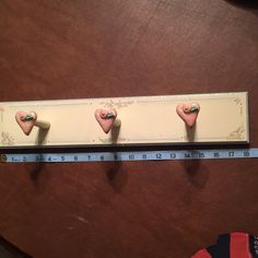 three heart shaped magnets are on a ruler