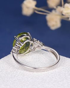 a close up view of a ring on a napkin with flowers in the background and blue sky