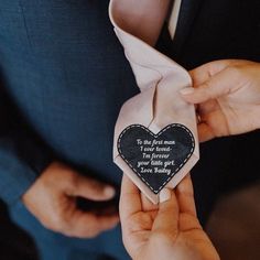 a person holding a heart shaped ornament with a poem on it's side