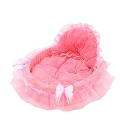 a pink pet bed with ruffles and bows on the bottom, in front of a white background