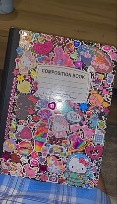 a notebook covered in stickers sitting on top of a chair