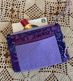 a purple purse with polka dots on it sitting on top of a doily covered table