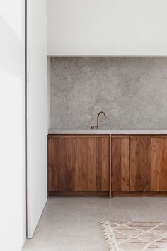 a kitchen with wooden cabinets and a white rug