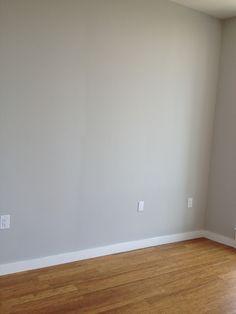 an empty room with hard wood floors and white paint on the walls, is seen in this image