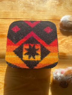 a close up of a cat's paw on top of a wooden floor with a rug