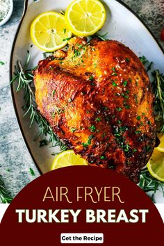 air fryer turkey breast on a plate with lemons and herbs