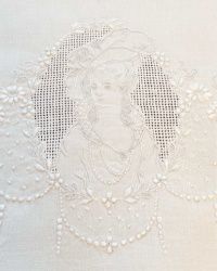 an embroidered white cloth with a woman's face on the side and pearls hanging from it