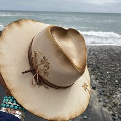 "California girls hand shaped and burned wool fedora. Features a binned heart crown with palm tree details. Underside has \"I wish they all could be California girls\" burned into the under brim. Hat band features ribbon leather and a seashell. One size fits most. Adjustable band inside hat. Crown is a little over 4 inches at the highest point and the brim is 3.5 inches." Fedora Burning, Burnt Hats, Cowboy Hat Crafts, Burned Hats, Hat Burning, Making Hats, Hat Bar, Glam Boho, Felt Cowboy Hats