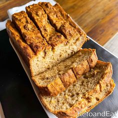 sliced loaf of banana bread sitting on top of a cutting board next to a knife