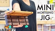 a person holding a wooden box that is made out of wood and has the words mini mortising jig on it