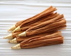 several pieces of cinnamon sitting on top of a white tablecloth with gold trimmings