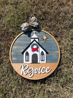 a wooden sign that says rescue with a church and bell on it in the grass