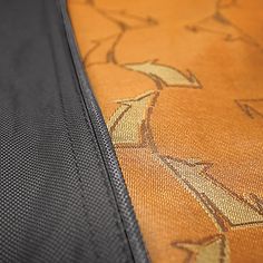 an orange and black piece of luggage with arrows on the cover is seen here in this close up photo