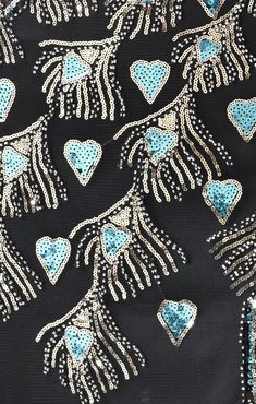 the back of a black dress with blue hearts on it and silver sequins