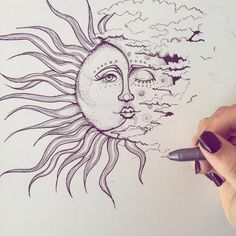 someone drawing a sun and moon on paper